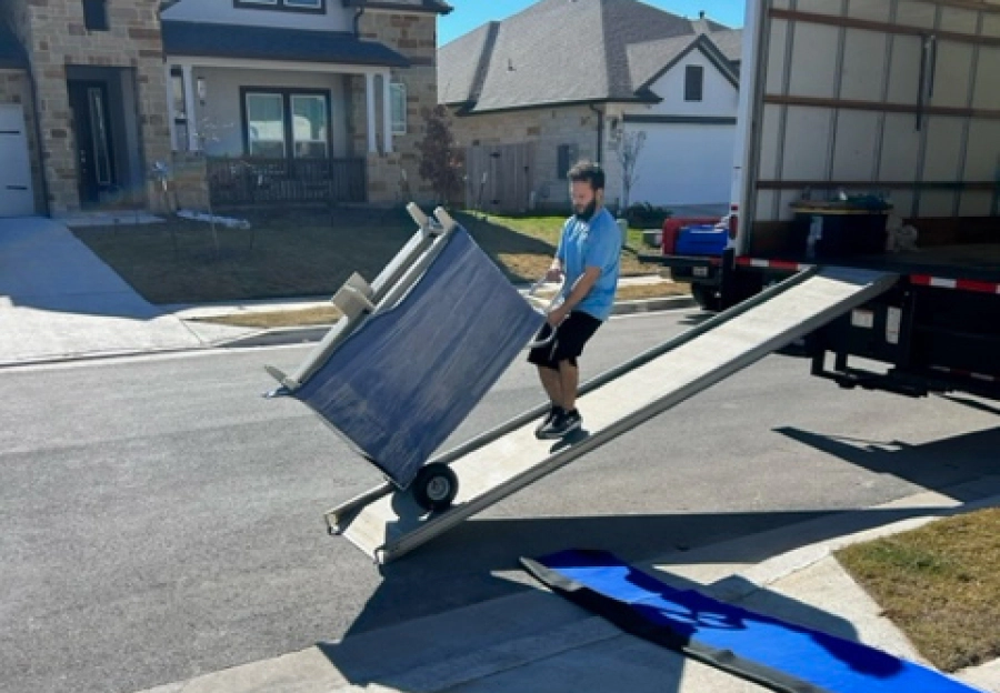 residential moving service man hauling furniture into truck
